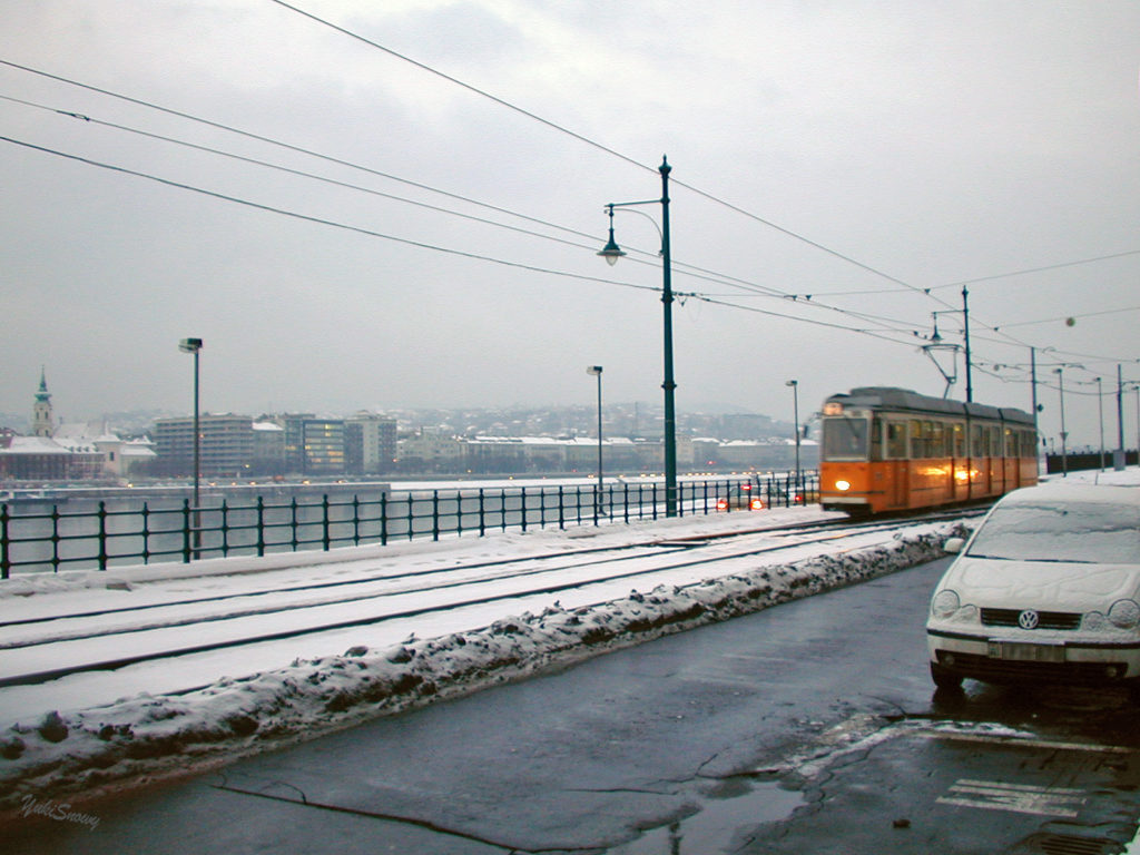 雪のブダペストでドナウ川とトラム